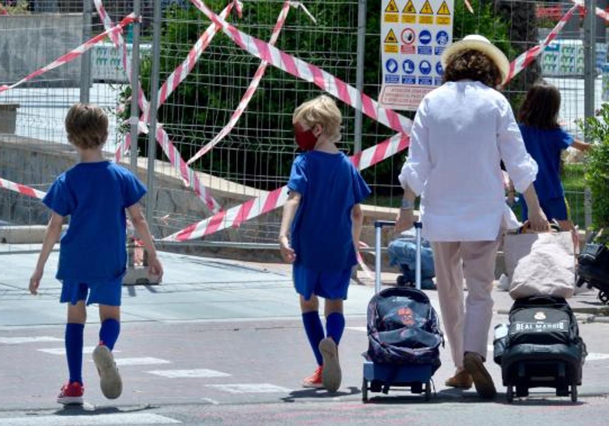 Una mujer recoge a sus hijos a la salida del colegio.