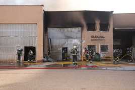 Los bomberos trabajan en el incendio de varias naves en Santovenia.