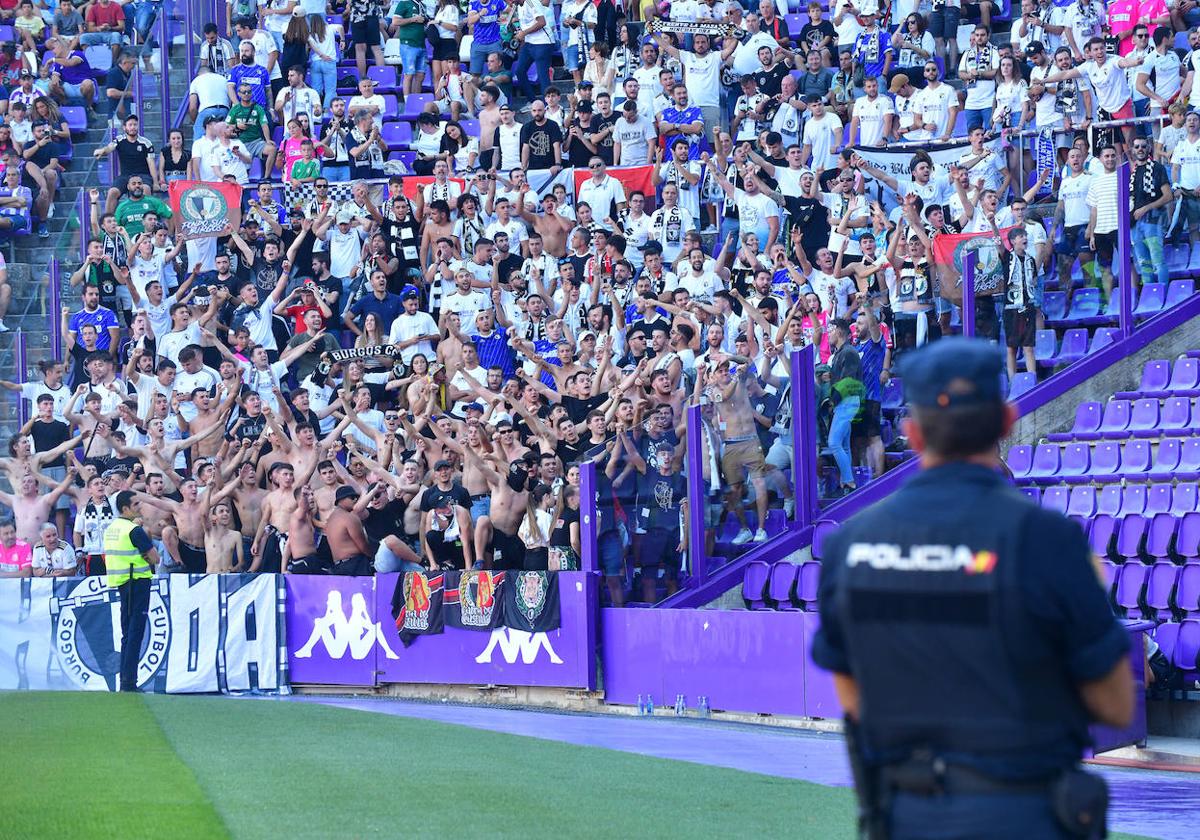 Los aficionados del Burgos cantan en pie hacia la grada del Pucela, custodiados por la Policía Nacional y la seguridad.