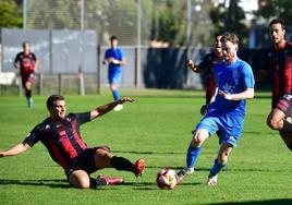 El defensa del Laguna se lanza al suelo para rebañarle un balón al jugador del Villaralbo.