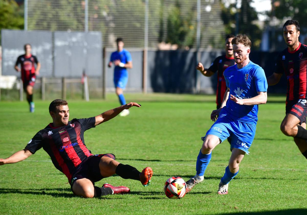 El defensa del Laguna se lanza al suelo para rebañarle un balón al jugador del Villaralbo.