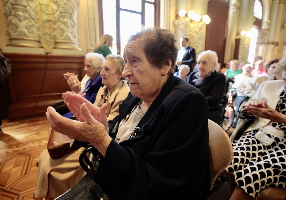 Los mayores homenajeados aplauden tras una de las intervenciones.