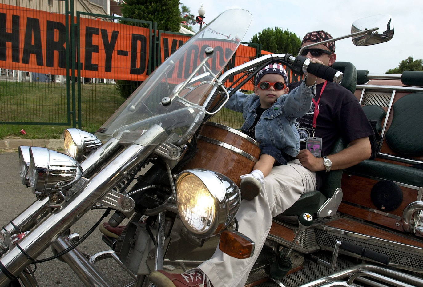 Un niño sujeta el manillar de una motocicleta Harley Davidson en Barcelona.