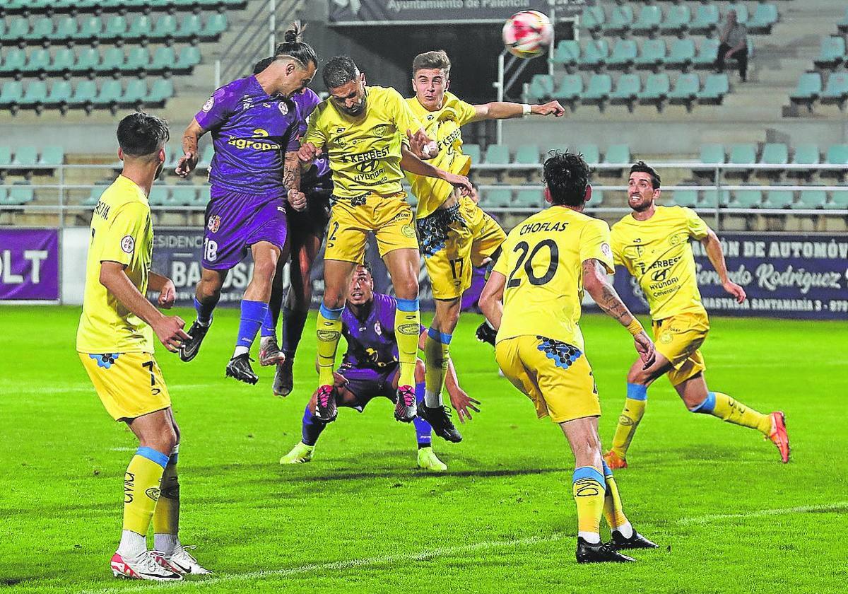 Valentín intenta rematar con la cabeza entre una nube de jugadores del Diocesanos.