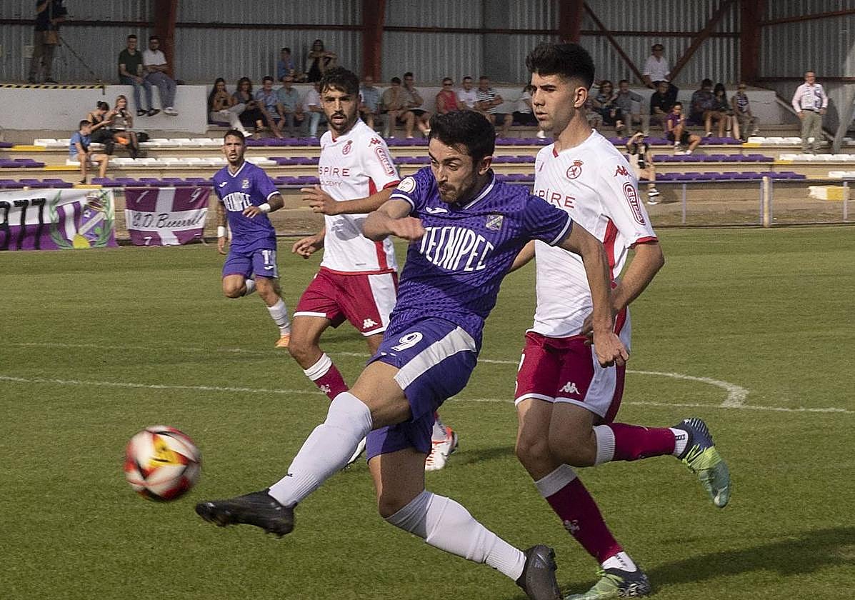 Diego intenta superar a dos rivales con un balón aéreo.