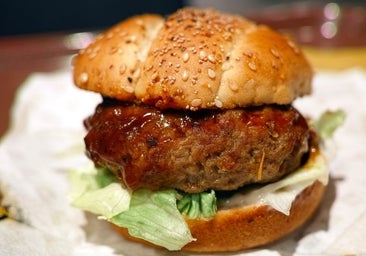 Jugosa hamburguesa casera con lechuga, tomate, pepinillos y queso