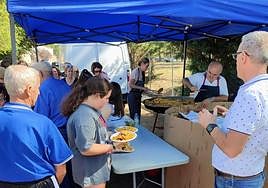 Participantes en la jornada recogiendo su ración de paella.