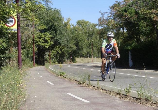 Un ciclista circula por la carretera junto al carril bici de La Overuela.