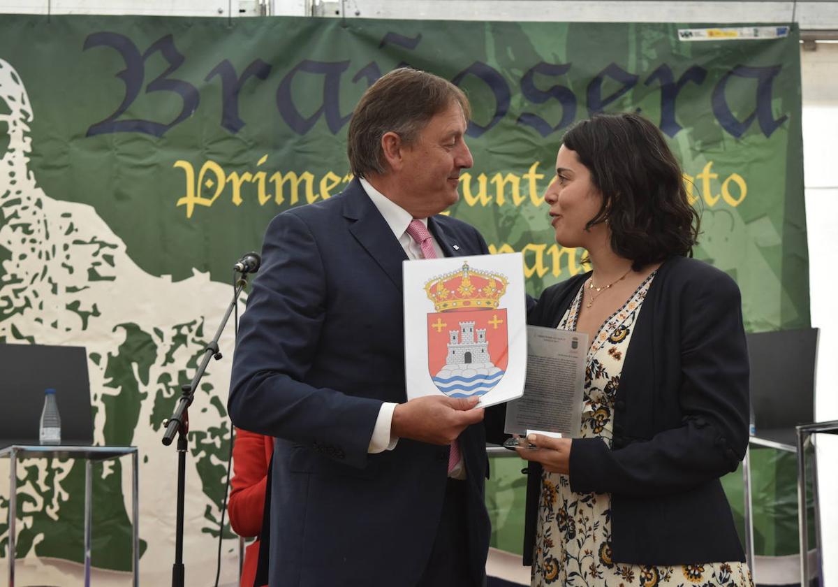 El alcalde de Brañosera entrega una copia del fuero y recibe una imagen del escudo de Magaz, que le entrega la regidora Patricia Pérez.