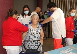 Personal sanitario vacuna a una mujer en un centro residencial de Segovia.