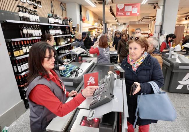 Una mujer paga su compra en la caja de un supermercado.