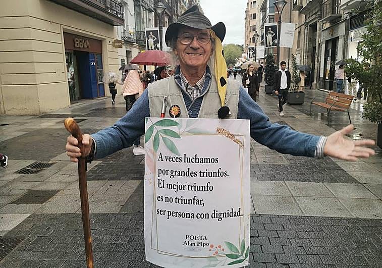 Alan Pipo declamando uno de sus poemas en la calle Santiago bajo la lluvia.
