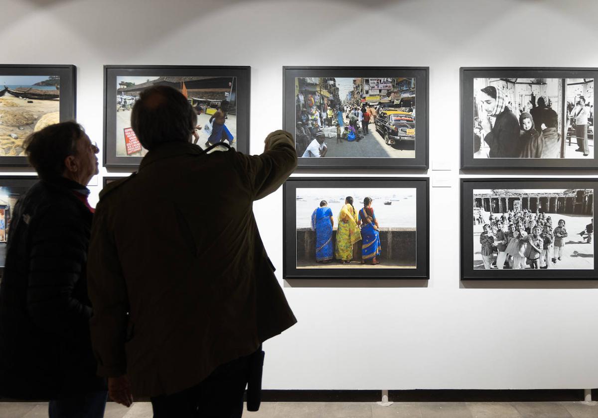 Dos visitantes observan fotografías de la muestra.