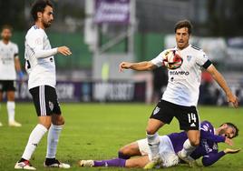 Fer Llorente se lleva un balón ante la mirada de Juan de la Mata.