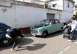 Una mujer fotografía uno de los coches clásicos en Husillos este domingo.