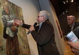 José Luis Onecha explica uno de sus retratos, hoy en la inauguración de la exposición.