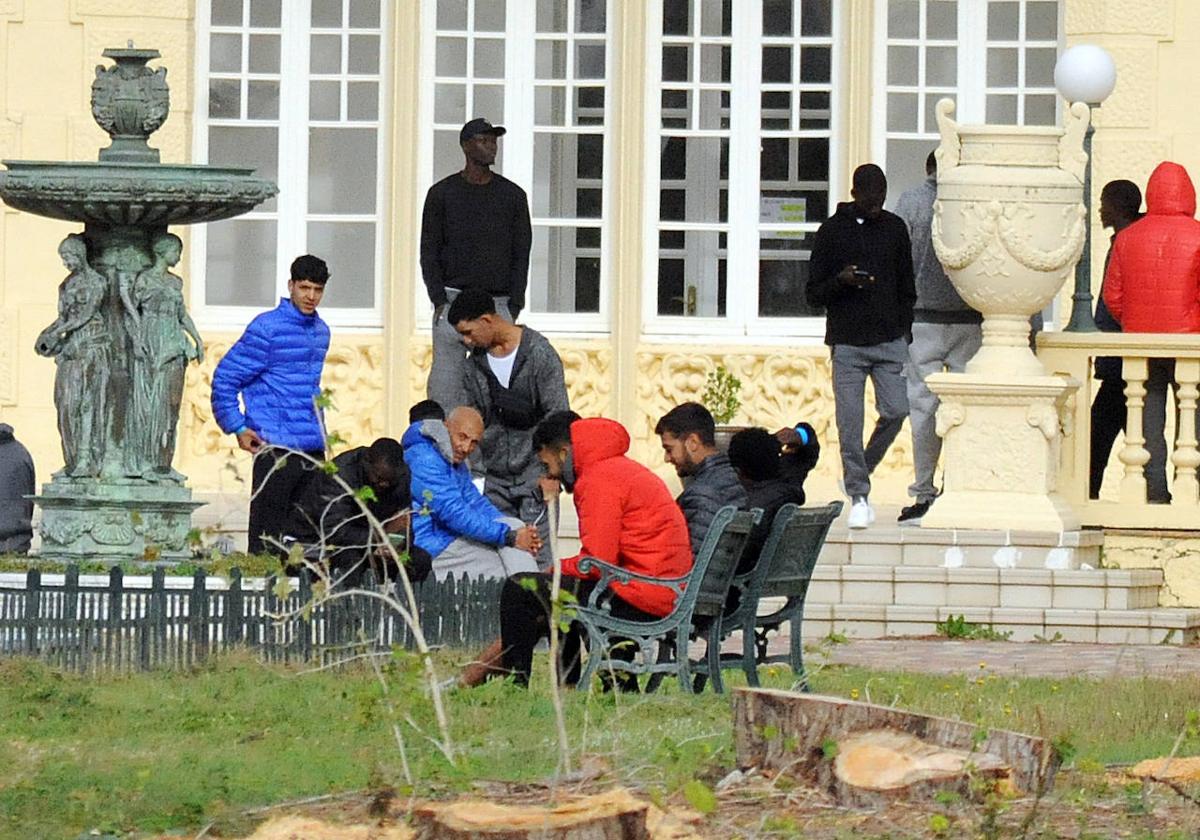 Los migrantes charlan en los jardines del balneario.