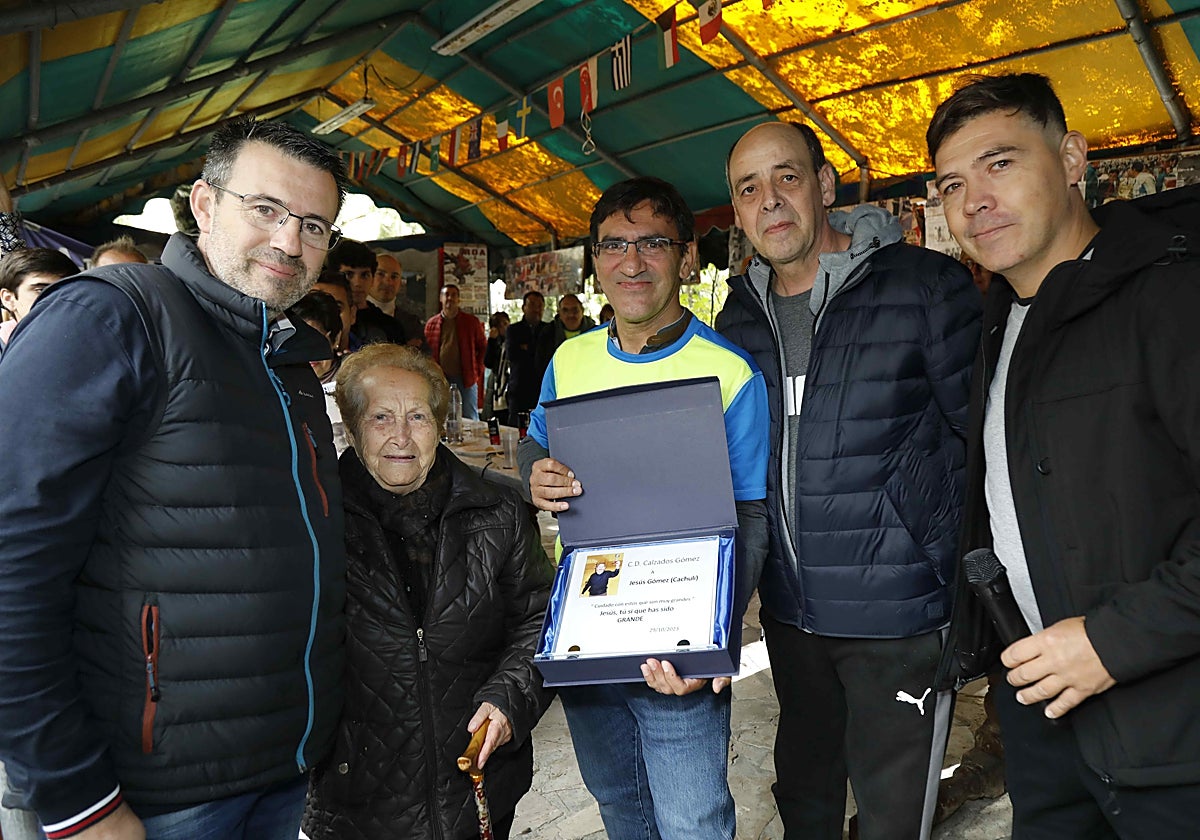 Milagros Muñoz recibe, de manos de su sobrino y exjugadores del CD Calzados Gómez, la placa homenaje a su marido, Jesús Gómez.