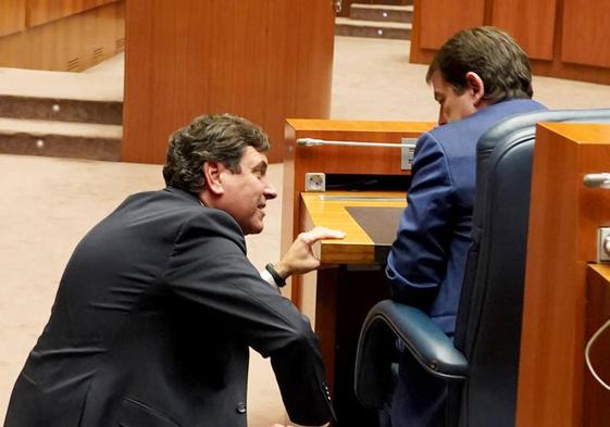 El presidente Mañueco habla con el consejero Fernández Carriedo en un pleno de las Cortes de Castilla y León.