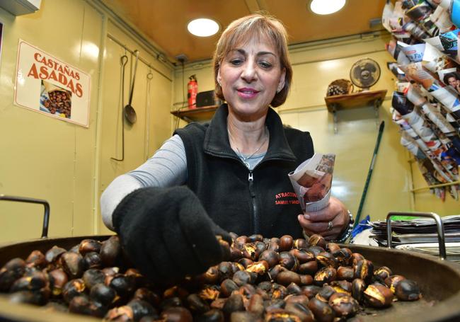 Begoña mete las castañas en el cucurucho, tras revisarlas.