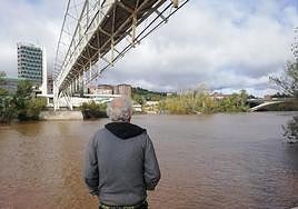Un hombre observa la crecida del Pisuerga bajo la pasarela del Museo de la Ciencia.