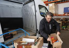 Un voluntario carga la furgoneta con pedidos en el Banco de Alimentos.