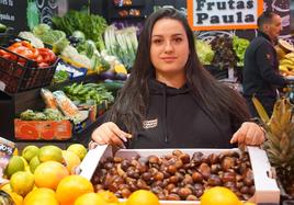 Paula Navarro muestra una caja de castañas en el Mercado del Val.