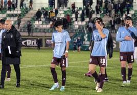 Jugadores de la Segoviana abandonan el terreno de juego con gestos de desilusión.