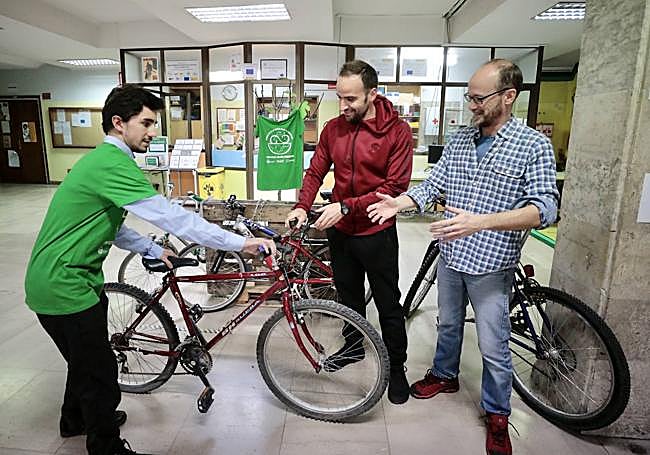 El alumno Bruno Ronda, de 17 años, entregando su vieja bicicleta a los profesores Jesús Gil y Borja Martín