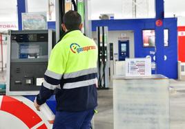 Un empleado prepara un surtidor en una estación de servicio.