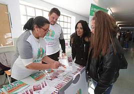 La presidenta de Alcer, Inmaculada Gutiérrez, ofrece información a una joven en el campus.