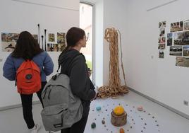Dos jóvenes contempla la exposición sobre los patios multisensoriales.