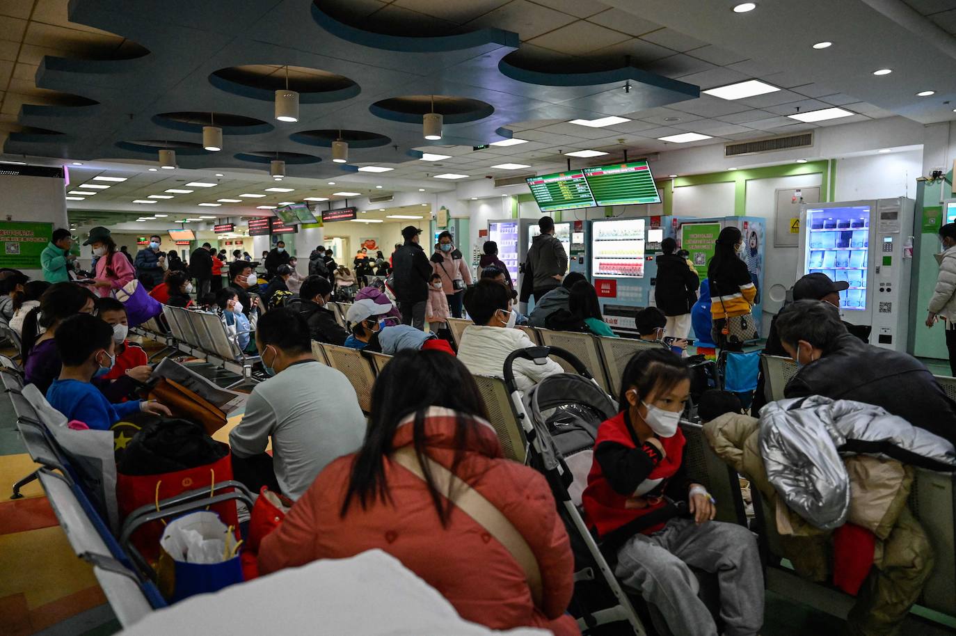 Niños enfermos esperan con sus familias en la sala de espera de un colapsado hospital de Pekín.