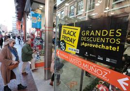 Varias personas entran a una de las tiendas con carteles alusivos al 'Black Friday' en sus escaparates.