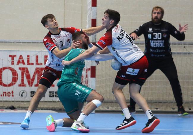 Dos jugadores naveros pugnan con un rival por un balón.