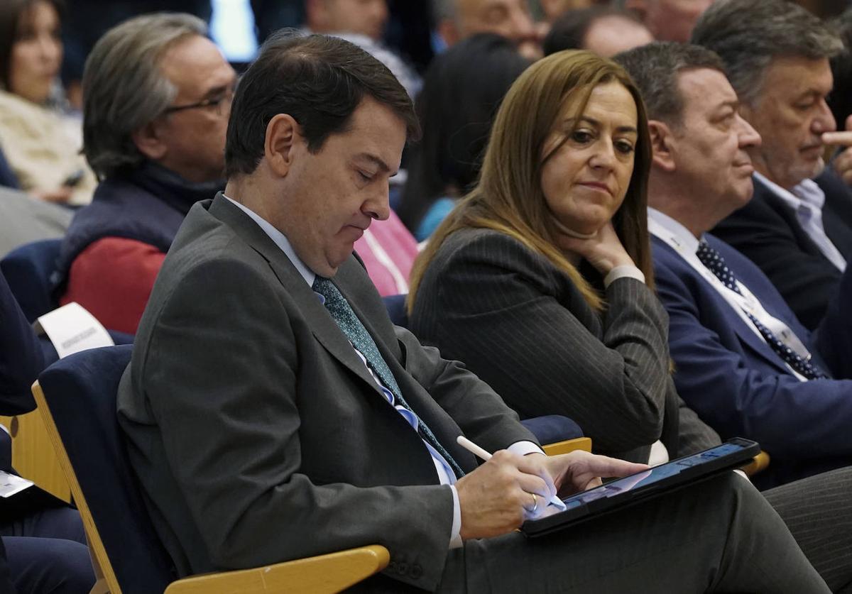 Alfonso Fernández Mañueco toma notas mientras Virginia Barcones observa, en el cierre de la Asamblea de la Federación Regional de Municipios y Provincias.