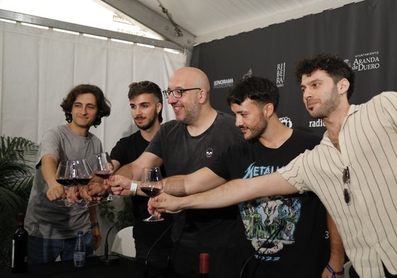 Arde Bogotá brinda con vino después de su concierto en Sonorama 2023, junto al director del festival (en el centro).