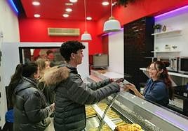 Varios jóvenes compran bocadillos durante su noche de fiesta en Ipan de la calle Pasión.