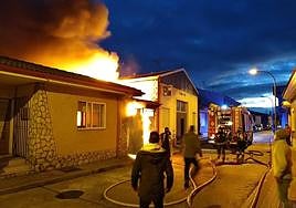Los Bomberos trabajan en el garaje que se ha incendiado.
