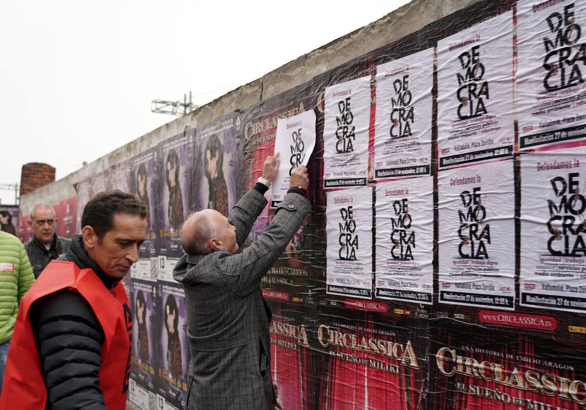 Los secretarios generales de CC OO y UGT Castilla y León, Vicente Andrés y Faustino Temprano, pegan carteles en una campaña contra los incumplimientos de la Junta en relación al diálogo social.