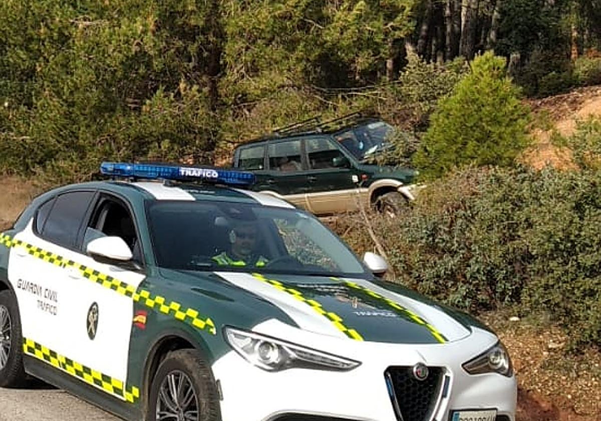 Lugar del accidente, con el todoterreno siniestrado a la derecha delante de una patrulla de la Guardia Civil.