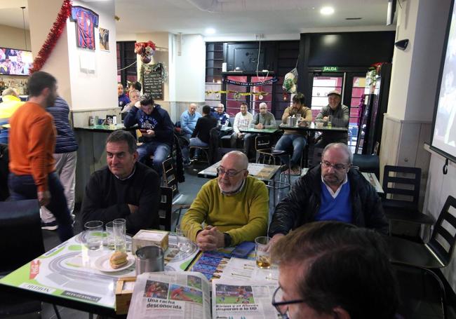 Aficionados de la Sego siguen el partido por la radio en un bar de la ciudad.