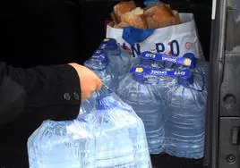 Un vecino de Las Jarillas descarga del coche garrafas de agua mineral.