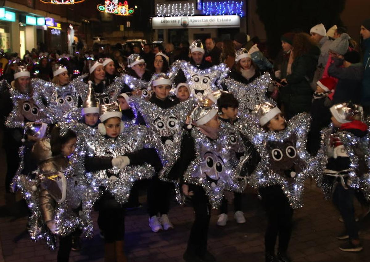 Imagen secundaria 1 - Arriba, Papá Noel recorre Cuéllar sobre su trineo tirado por unos renos; abajo, un grupo de escolares disfrazados de estrellas y a la derecha, participantes en la recepción motera a Santa Claus.