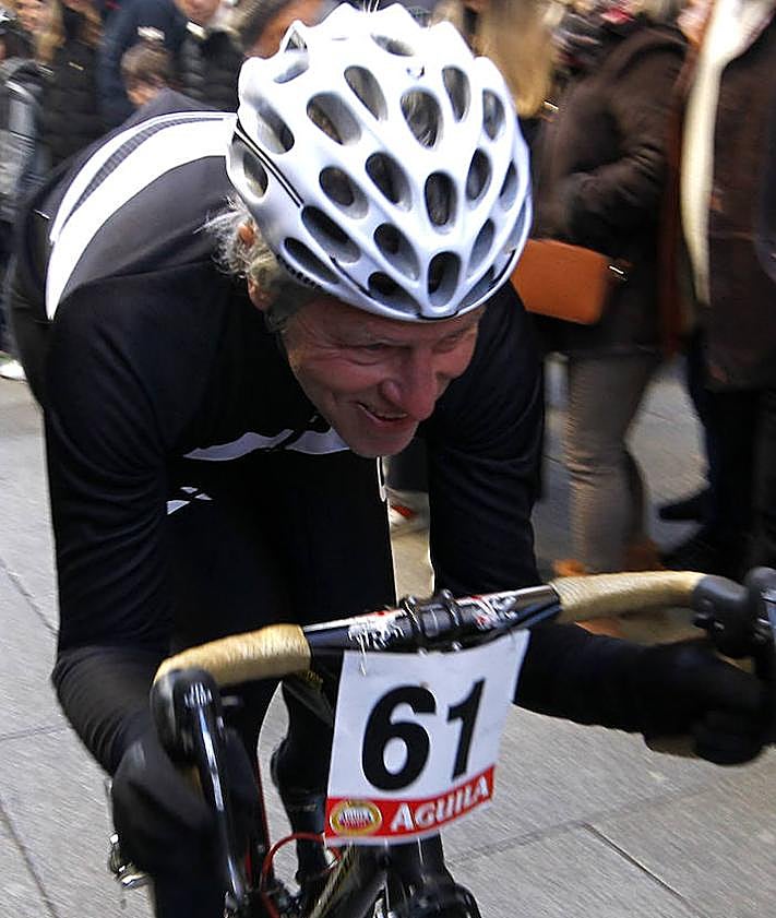 Imagen secundaria 2 - Arriba, Perico Delgado saluda a la multitud que se ha acercado este lunes a la carrera. Abajo a la izquierda, uno de los corredores resbala y pone pie en tierra; a la derecha, un participante se agarra al manillar con fuerza.