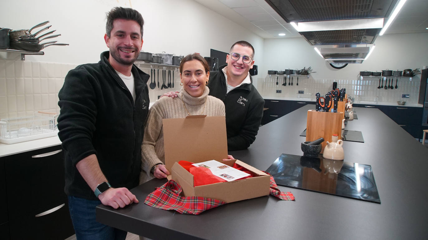 Laín, Yaiza y Sergio, los tres emprendedores de Fuera de Carta preparando uno de sus menús navideños con lazo rojo