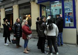 Clientes hacen cola en una administración de lotería del centro histórico de Segovia.