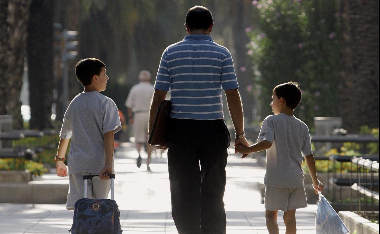 Un padre acompaña a sus hijos al colegio en Valencia. 