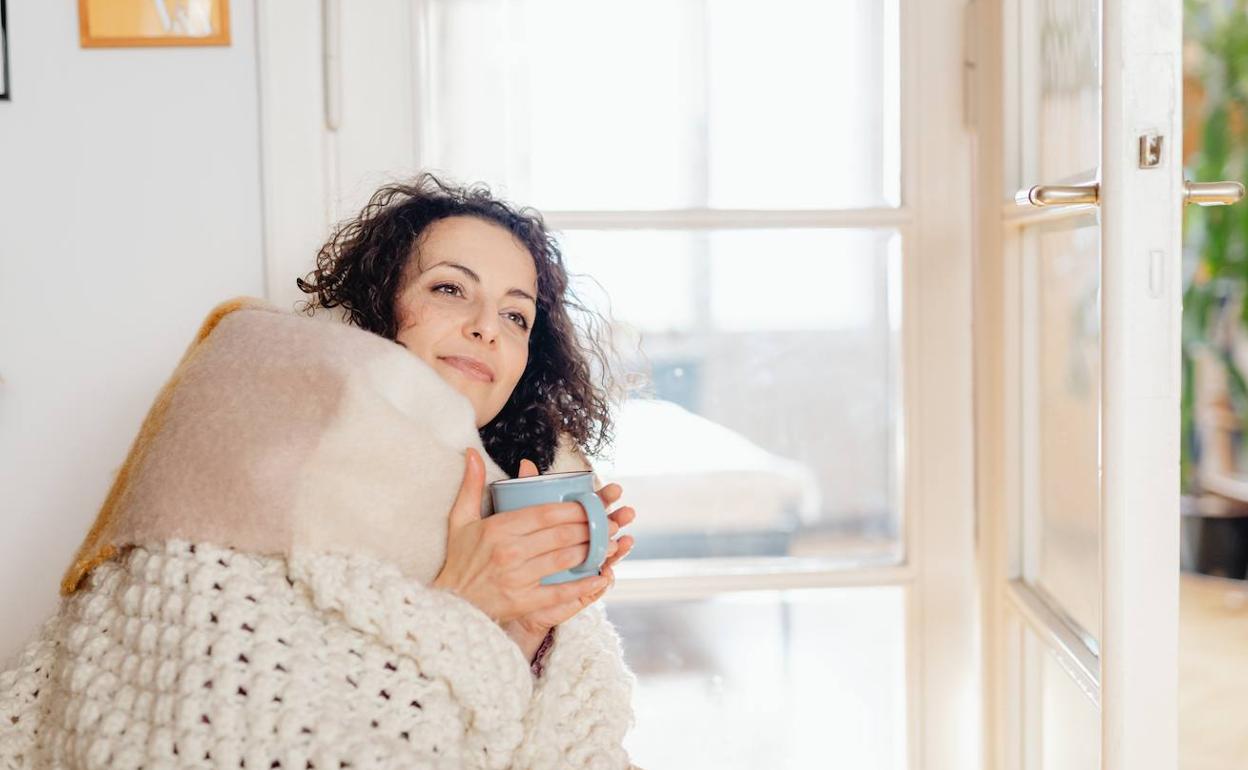 Mujer afónica tomando una infusión de tusilago.