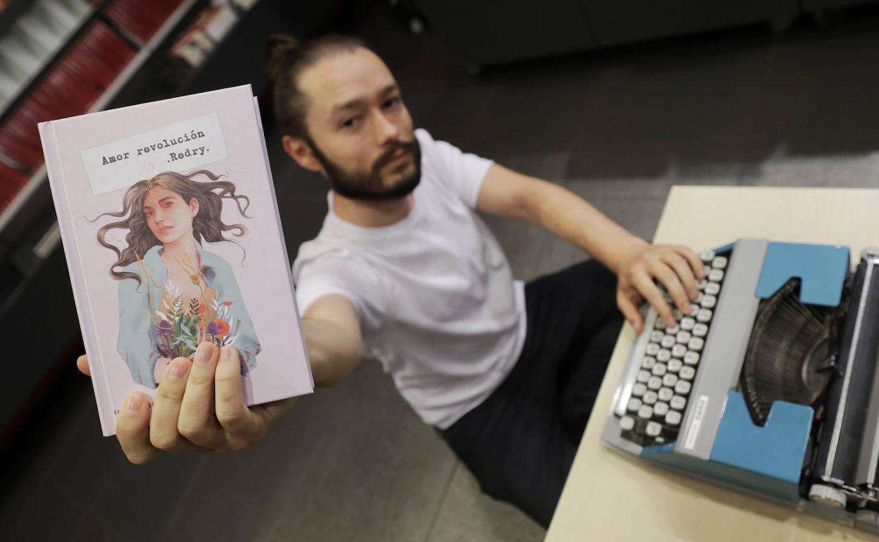 Redry, con su máquina de escribir y un ejemplar de 'Amor revolución'. 
